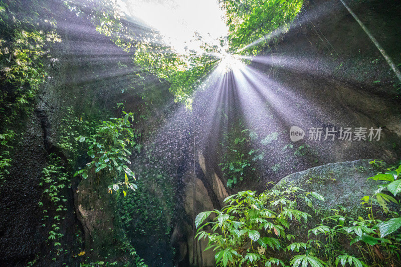 美丽的阳光穿过Tukad Cepung瀑布，印度尼西亚巴厘岛